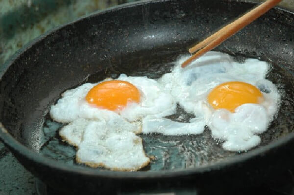 Ốp trứng trong chảo dầu, đun lửa nhỏ để trứng chín đều