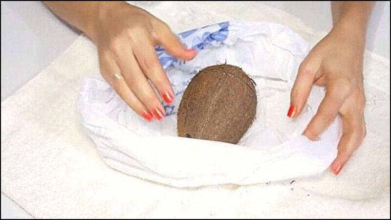 Cho quả dừa vào túi đựng rác và đập vào bề mặt cứng